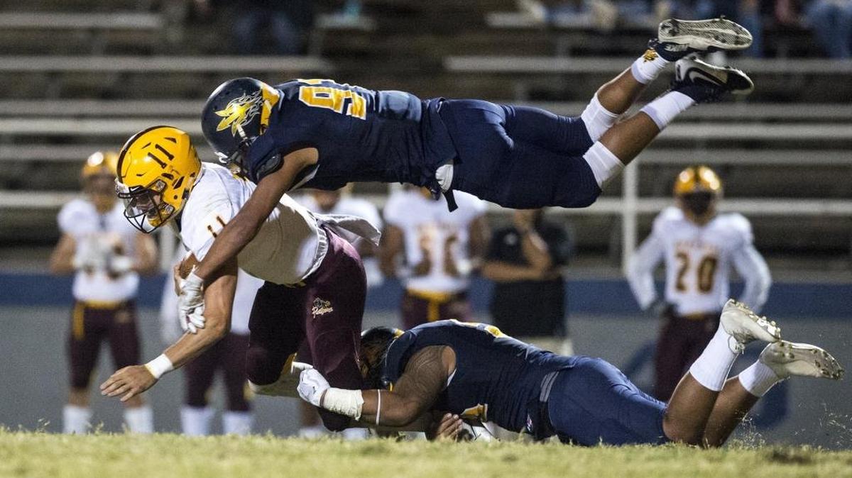 Merced College sophomore Kalauga Laloulu (55) and freshman David Perales (91) sack Hartnell College freshman quarterback Devon Daich (11) during a game at Stadium '76 in Merced, Calif., on Saturday, Oct. 14, 2017. The Blue Devils beat the Panthers 33-28.