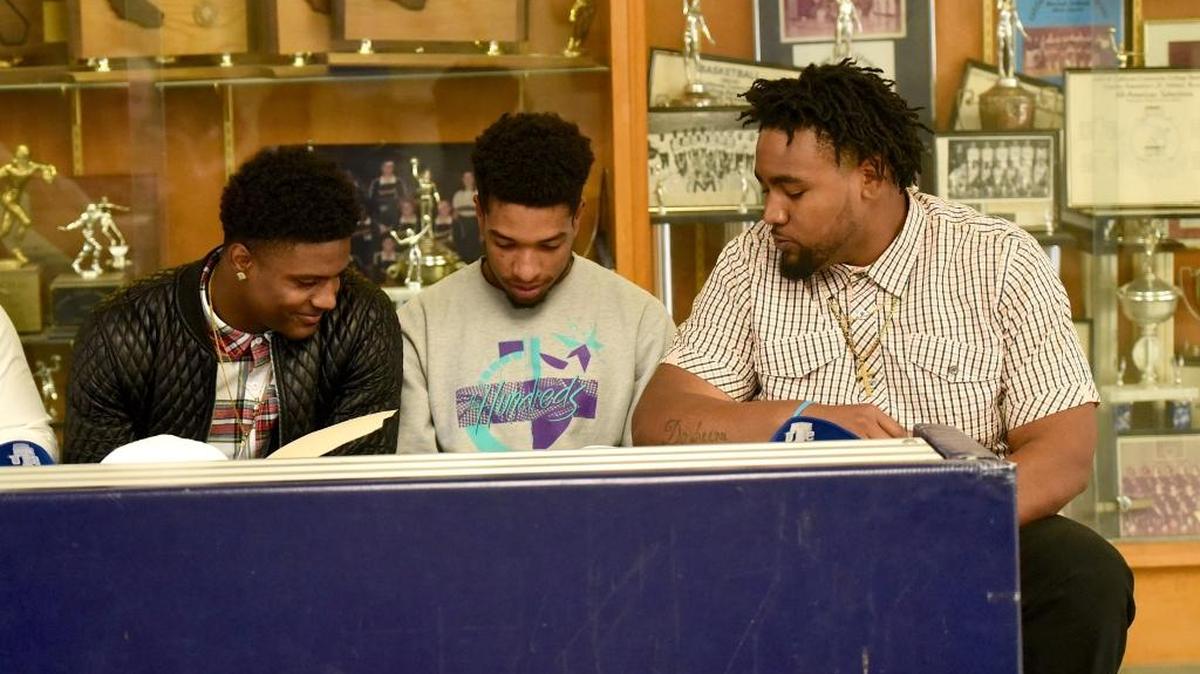 From left: Merced College’s Earl Chambers, Josh Stevens and Xzavier McCallister look over their paperwork during a signing day event half at the MC gym Wednesday, Feb. 3, 2016.
