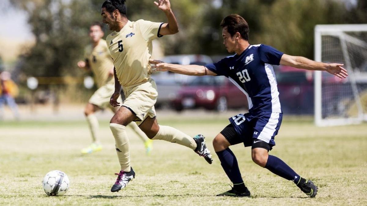 UC Merced junior Cruz Trenado (5) gets past Menlo College freshman Noa Kerr (20) during a Tuesday’s soccer match in Merced. Below, UC Merced senior Cody Golbad (14) attempts to control the ball. The Oaks beat the host Bobcats 1-0.