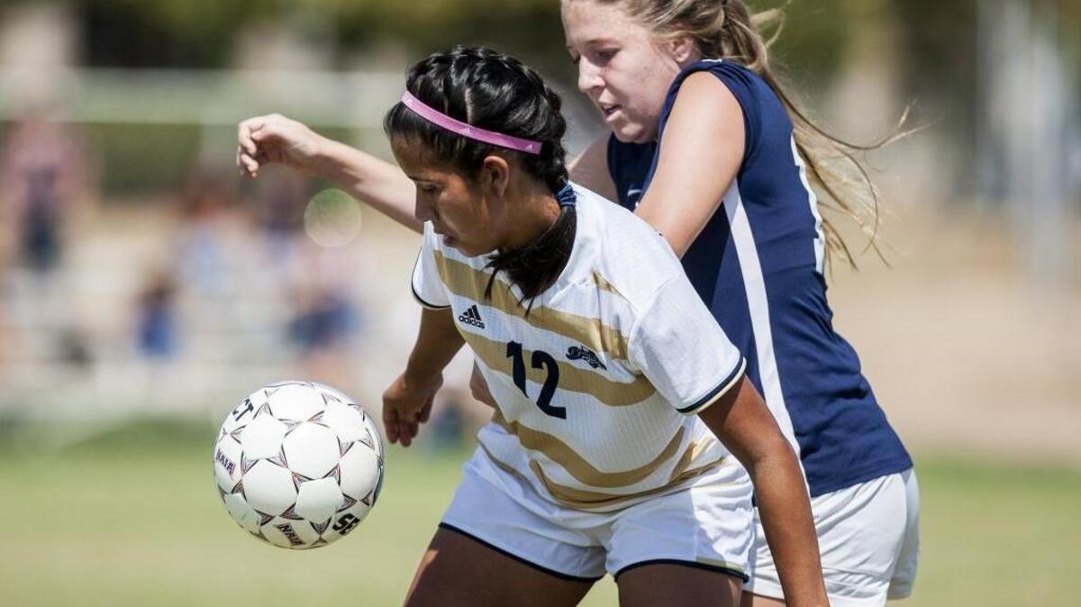 University of California, Merced senior Veronica Villacorta (12) protects the ball against Hope International University’s Taylor Hollywood (15) during a game at UC Merced in Merced, Calif., Thursday, Sept. 8, 2016. The game ended in a 1-1 tie.