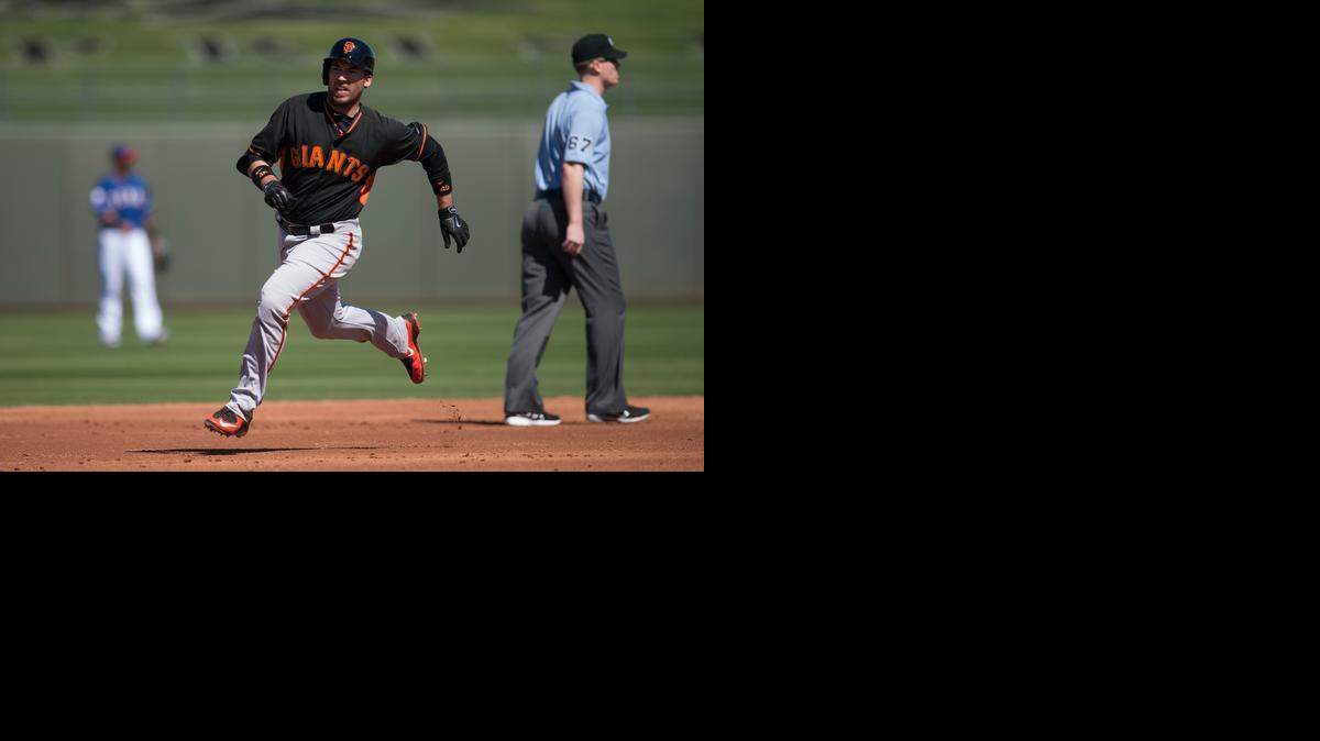 
The San Francisco Giants’ Travis Ishikawa heads for third base after hitting a two-run triple in the top of the second inning on March 6, 2015 in the Cactus League game between the Texas Rangers and Giants at Surprise Stadium, in Surprise, Arizona.
