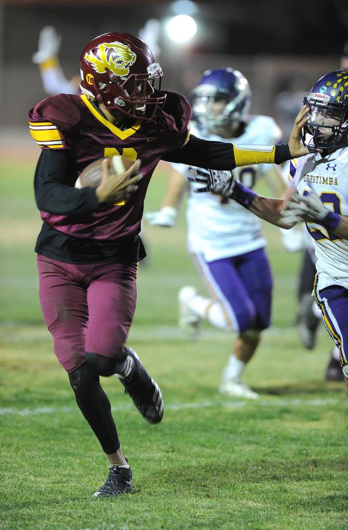 Los Banos High School quarterback, Dasani Tate stiff arms an Orestimba defender enroute to scoring a touchdown Fri., Nov. 2, 2018 at Loftin Stadium in Los Banos.