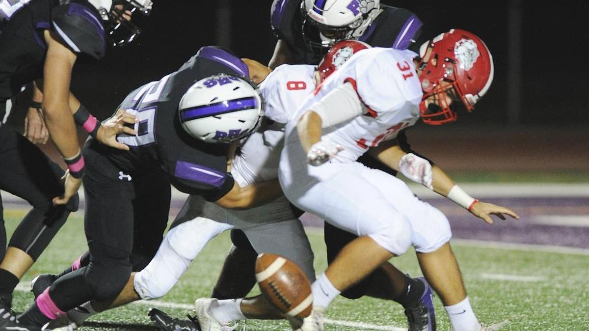 Ceres High School running back, Andrew Alcala, right, has the ball stripped in the first quarter by a Pacheco High defender Fri., Oct. 5, 2018 at Veterans Stadium in Los Banos.