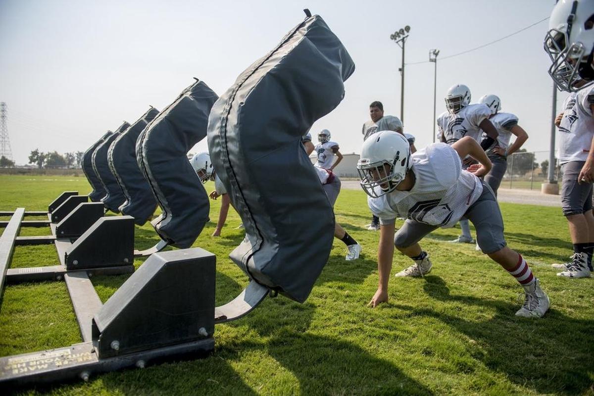 Stone Ridge Christian players prepare to hit the tackling sled during football practice in Atwater, Calif., on Friday, Aug. 3, 2018.