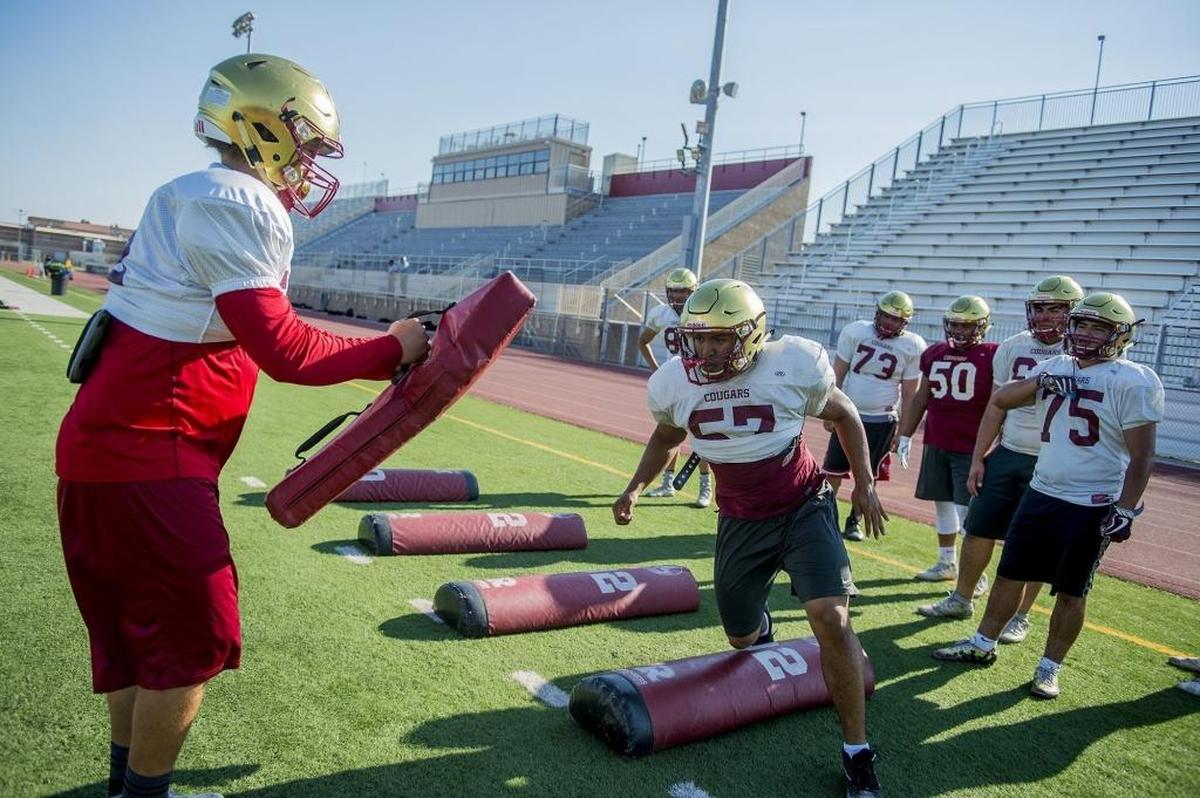 Golden Valley’s Simon Valdovino, right, runs through drills during football practice at Golden Valley High School in Merced, Calif., on Wednesday, Aug. 1, 2018.