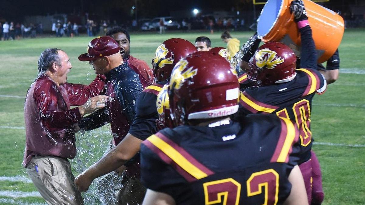 Los Banos defensive back, Conner Cascia dumps Gatorade on head coach, Dustin Caropreso after the Tiger 28-21 victory over crosstown rival Pacheco High School Fri., Oct. 26, 2018 at Loftin Stadium in Los Banos.