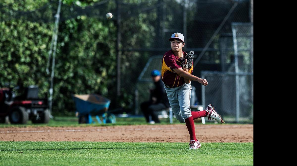 
Los Banos third baseman D.J. Lomeli throws to first base to record an out against San Leandro last month.
