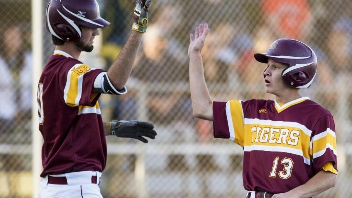 Los Banos' Trent Mallonee (13) celebrates with teammate Kody Cardoza (10) after scoring a run during the Merced County All-Star Game last year. Both Tigers players earned major Western Athletic Conference awards with Mallonee being named MVP and Cardoza being selected as the Pitcher of the Year.