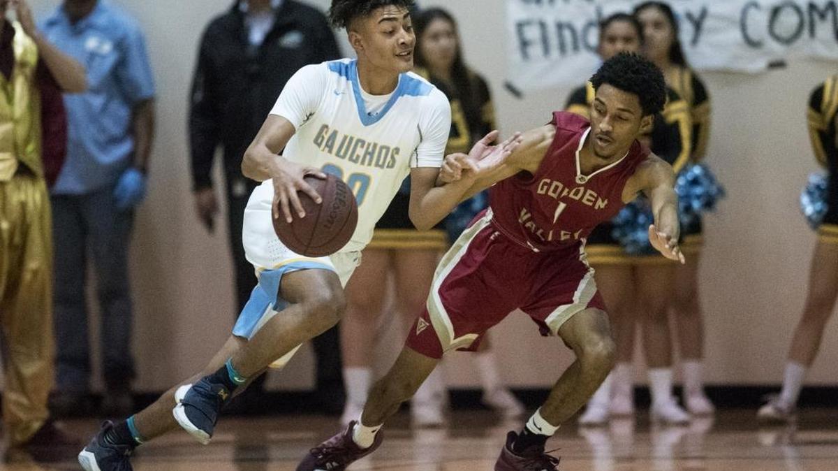 El Capitan senior TJ Wills (20) dribbles past Golden Valley senior Devon Martinez (1) during a game at El Capitan High School in Merced, Calif., on Wednesday, Jan. 31, 2018. The Gauchos beat the Cougars 66-56.