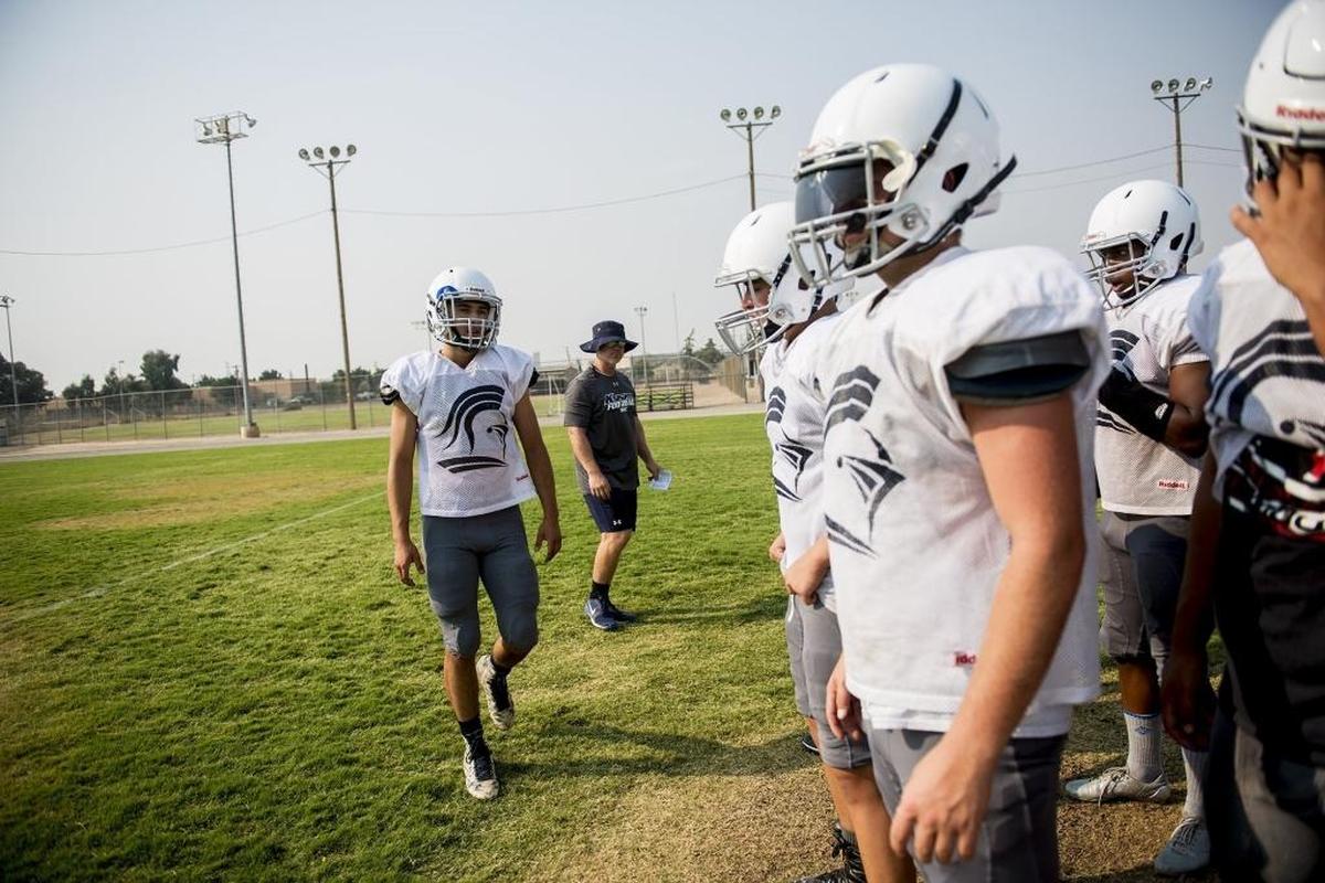 Stone Ridge Christian quarterback Ethan Moradzedeh, left, calls the play during football practice in Atwater, Calif., on Friday, Aug. 3, 2018.