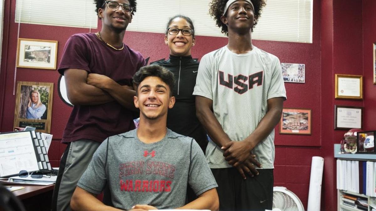 Golden Valley High School senior Shawn Bettencourt, center, poses for photos with friends Rodney Evans, left, Naomi Peterson, back center, and Rodney Winzer, right, at Golden Valley High school in Merced, Calif., on Wednesday, May 31, 2017. Bettencourt has signed a letter of intent to attend California State University, Stanislaus.