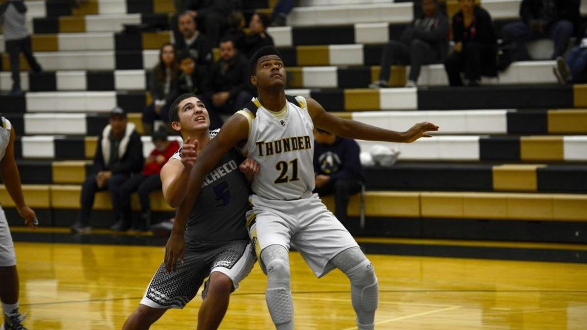 Buhach Colony center Darius Mack (21) boxes out Pacheco's Vinny Roque during a 68-32 Thunder victory. Tuesday, Dec. 15, 2015 in Atwater.