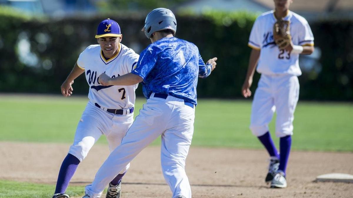 Livingston senior second baseman Ernie Angel (7) tags out Mountain House senior Nick Aguilera (1) during a game at Memorial Ballpark in Atwater, Calif., on Thursday, April 20, 2017. The Mustangs beat the Wolves 5-0.