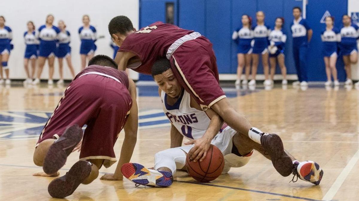 Atwater senior Reggie Ricks (4) Golden Valley junior August Tangaan (24) and Golden Valley senior Isaac Cropper (11) fight for possession of the ball during a game at Atwater High School in Atwater, Calif., on Wednesday, Feb. 8, 2017. The Cougars beat the Falcons 62-51.
