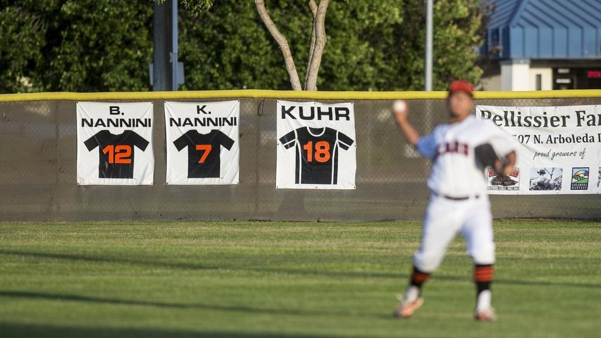 Signs honoring Brian and Kevin Nannini hang in center field as the Merced baseball team warms up before their game against Golden Valley in the 13th annual Nannini Game at Merced High School in Merced, Calif., Friday, April 29, 2016. The game is named for Merced brothers Kevin and Brian Nannini who drowned in a boating accident in 2004. Prior to the game, a ceremony was held and seniors from both teams were awarded scholarships from the Kevin and Brian Nannini Scholarship Foundation.