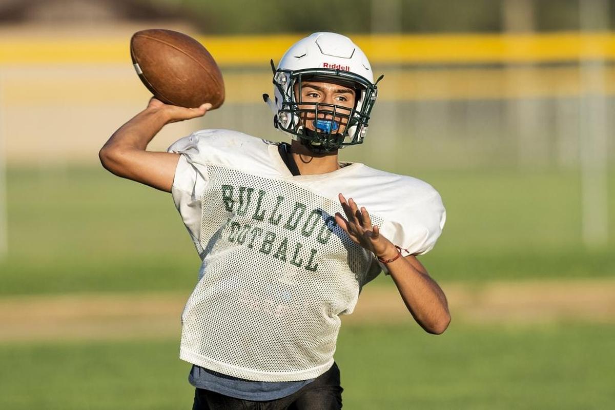 Le Grand quarterback Ivan Perez throws a pass during football practice at Le Grand High School in Le Grand, Calif., on Thursday, Aug. 2, 2018.