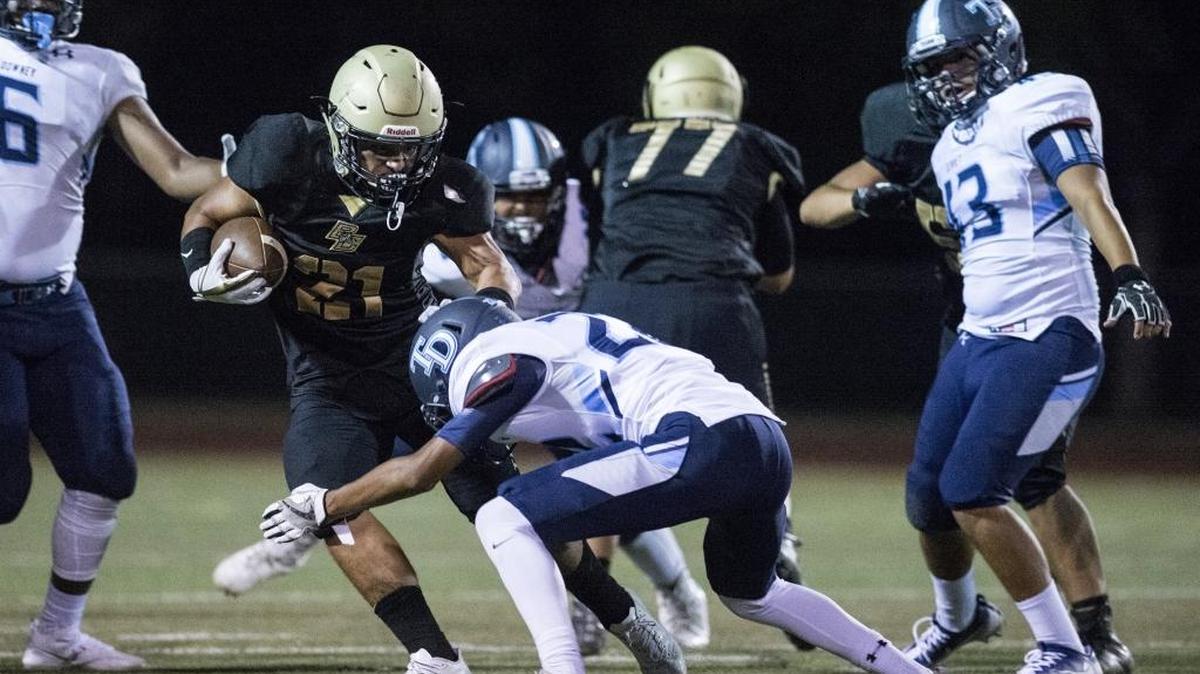 Buhach Colony senior Christian Quirarte (21) rushes the ball during a game against Downey at Atwater High School in Atwater, Calif., on Friday, Aug. 25, 2017.