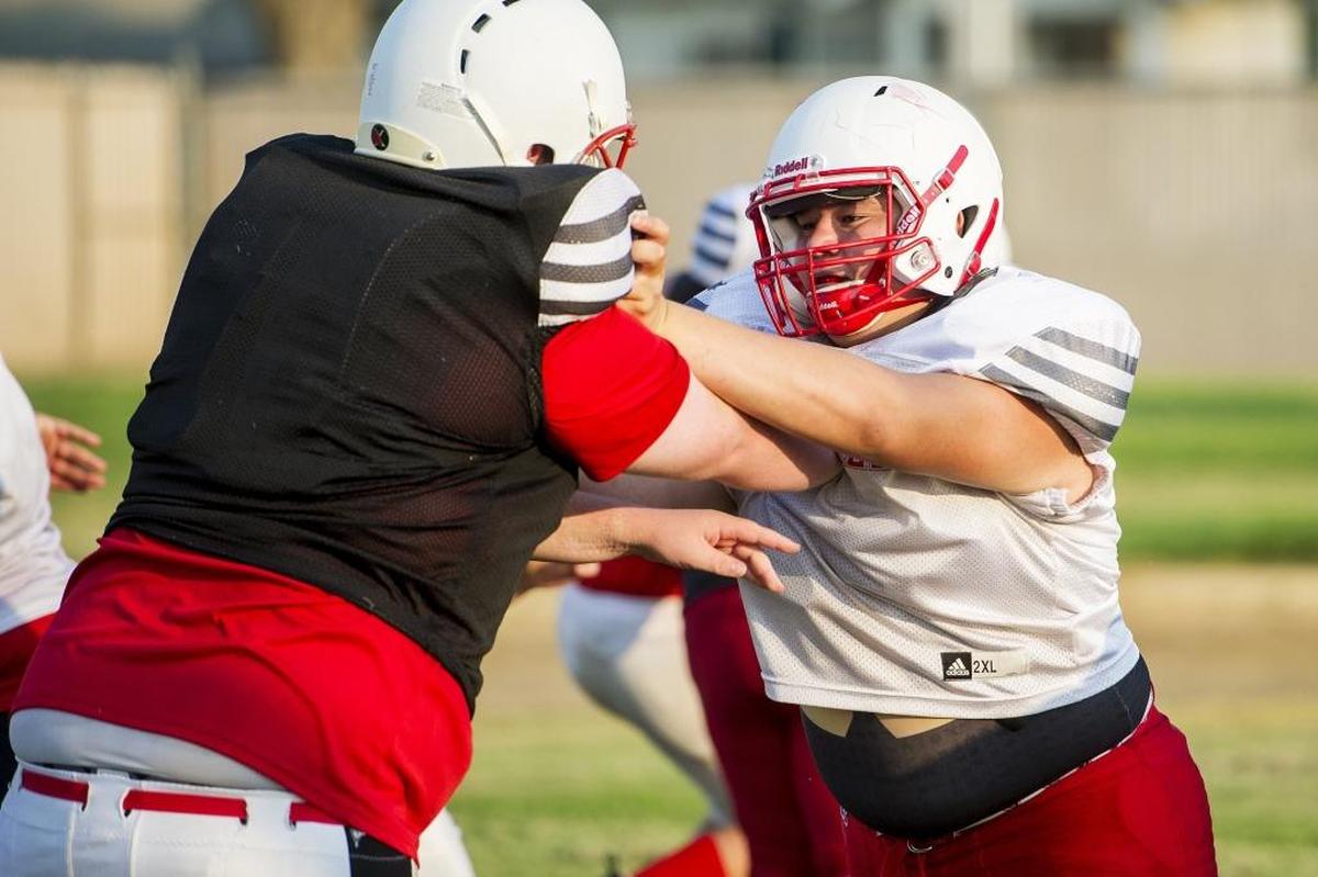 Gustine’s Genaro Hernandez blocks during football practice at Gustine High School in Gustine, Calif., on Thursday, Aug. 9, 2018.