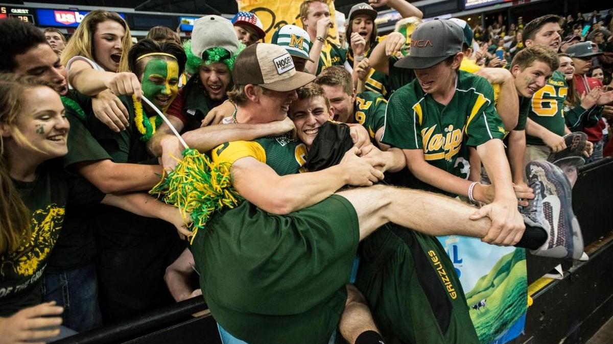 Mariposa Grizzlies players leap into the student section after defeating the Brookside Christian Knights 79-75 in overtime during the Sac-Joaquin Section Division V Championship game.