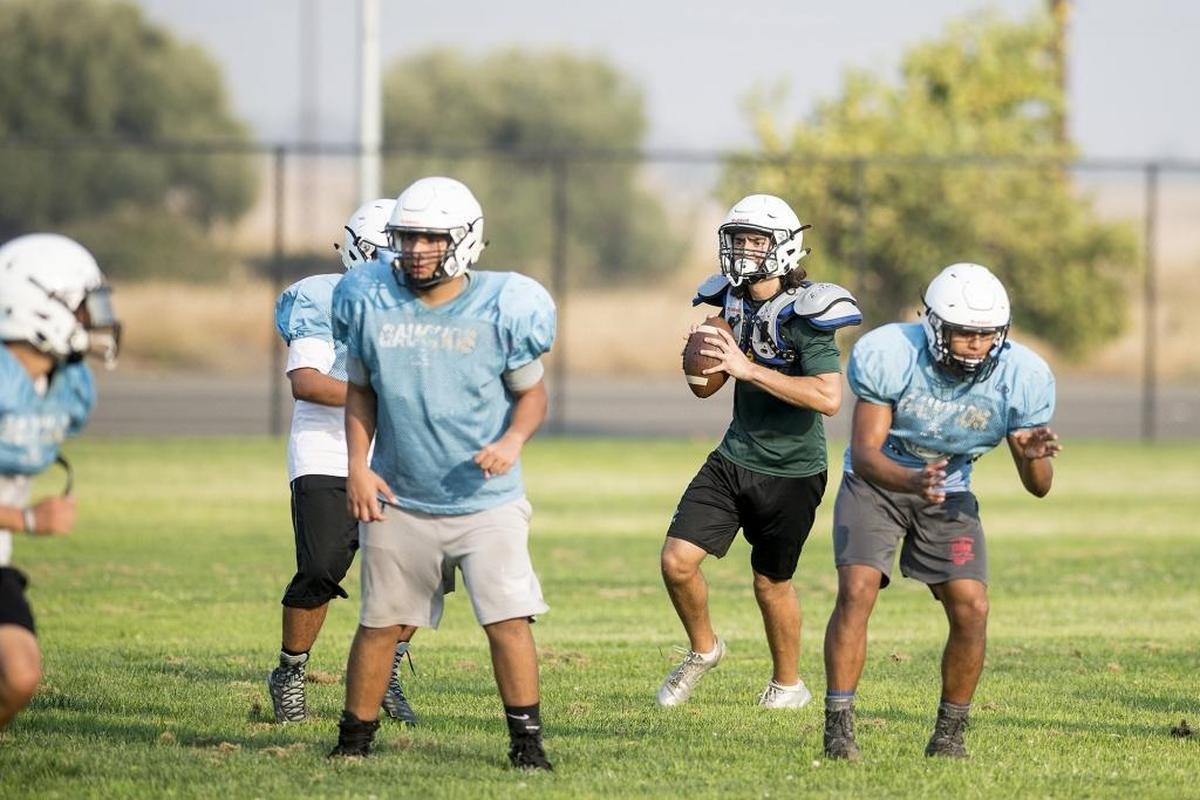 El Capitan quarterback Jacob Tanori drops back to pass during football practice at El Capitan High School in Merced, Calif., on Wednesday, Aug. 8, 2018.