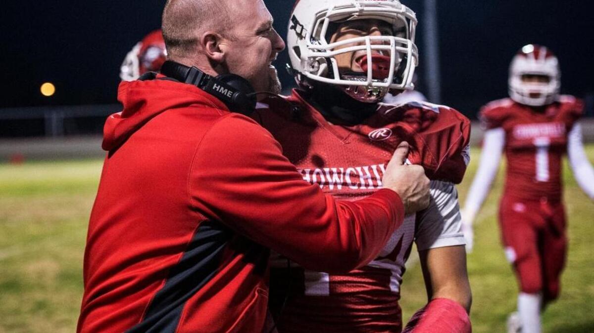 Chowchilla head coach Alex Pittz hugs senior running back Alex Gutierrez after Gutierrez rushed for a touchdown during the Central Section Division IV semifinal against Kerman at Chowchilla High School in Chowchilla, Calif., Friday, Nov. 27, 2015. The Redskins beat the Lions 46-27.