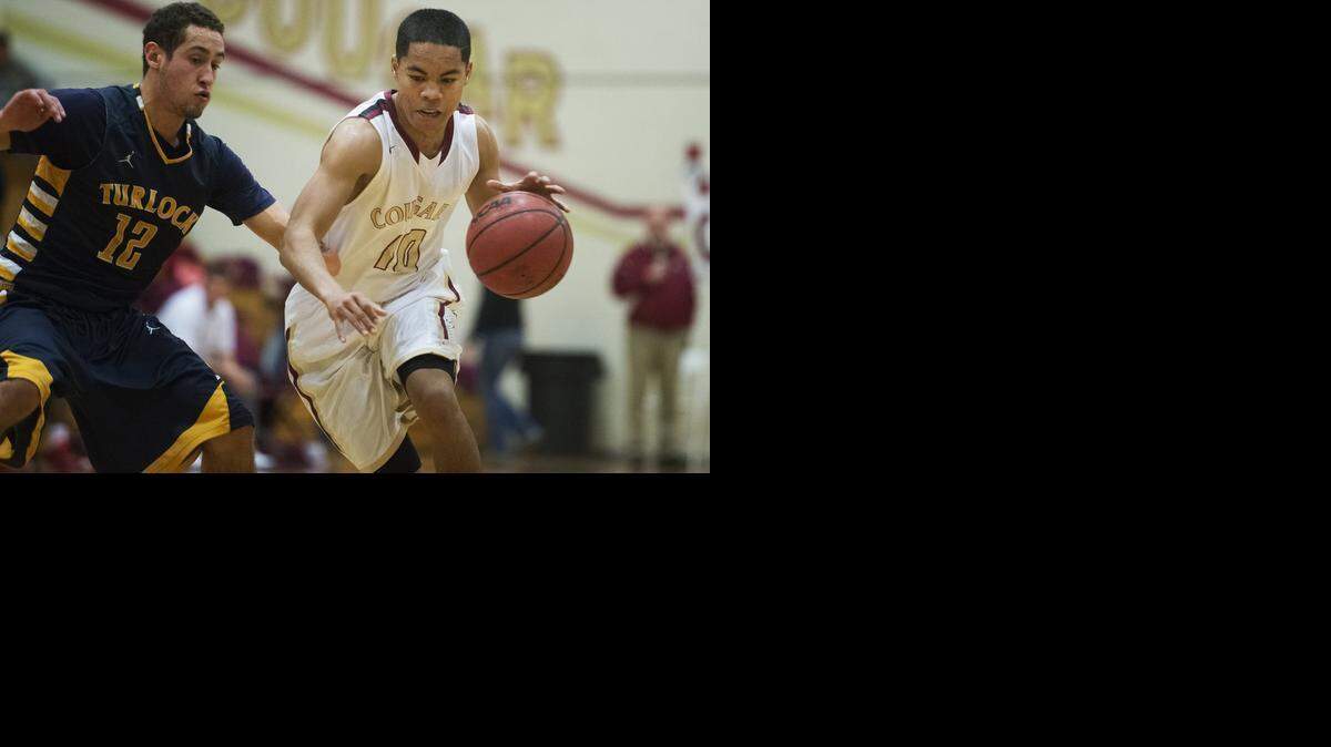 Golden Valley senior Isaac Daniel, right, works to avoid <137>(10) gets past <137>Turlock senior Demsen McFaddin. Daniel finished with nine points, McFaddin with 17 in Turlock’s win. <137> (12) during a game at Golden Valley High School in Merced, Calif., Friday, Feb. 6, 2015. The Bulldogs beat the Cougars 52-36.<137>