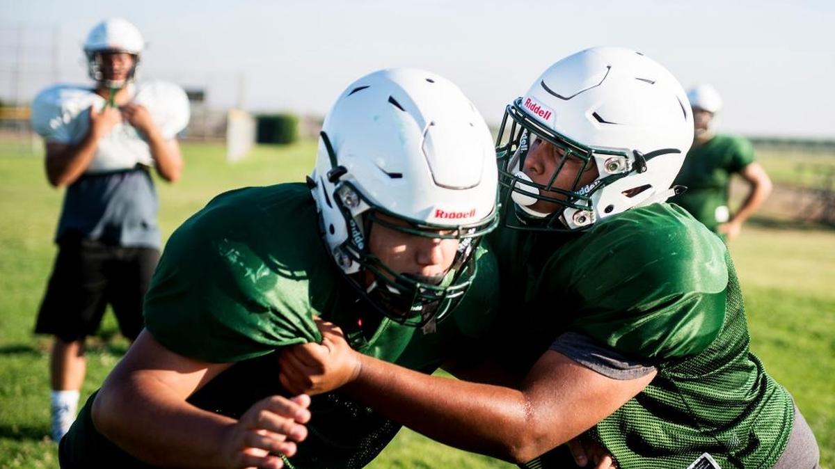 Le Grand’s Antonio Puente, right, runs a blocking drill during football practice at Le Grand High School in Le Grand, Calif., on Thursday, Aug. 2, 2018.