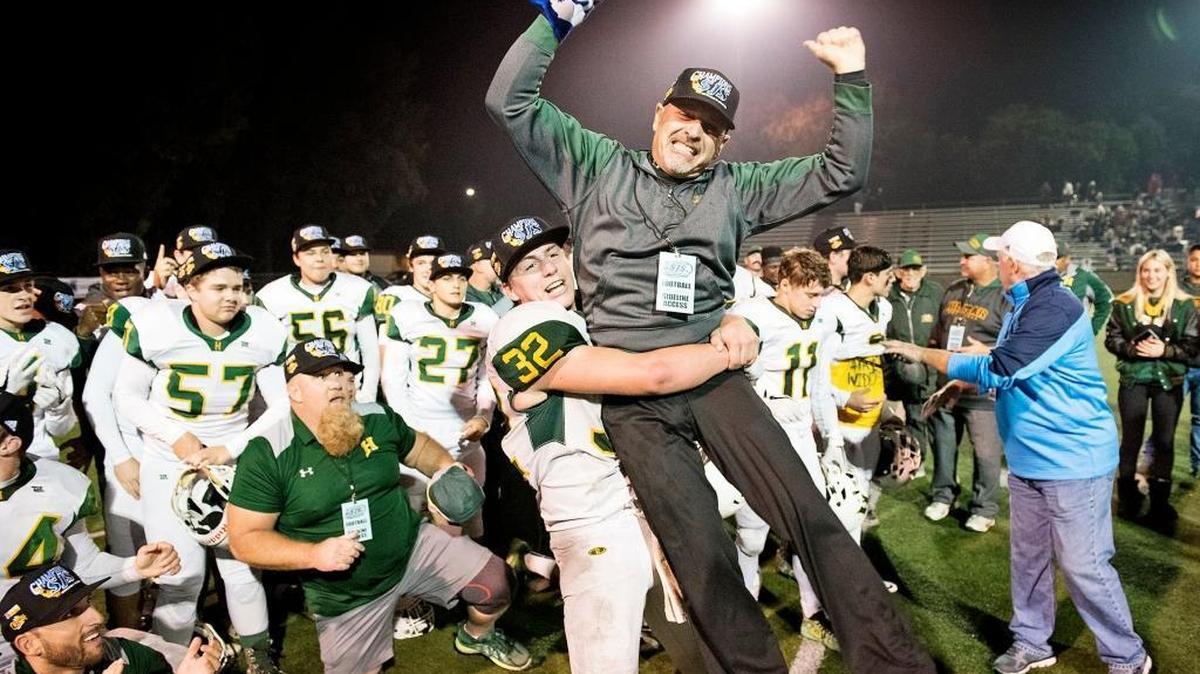 Hilmar running back Justin Rentfro lifts his coach Frank Marques after the Yellowjackets beat the Modesto Christian Crusaders 42-13 in the Sac-Joaquin Section Division VI final at Lincoln High School in Stockton on Nov. 25.