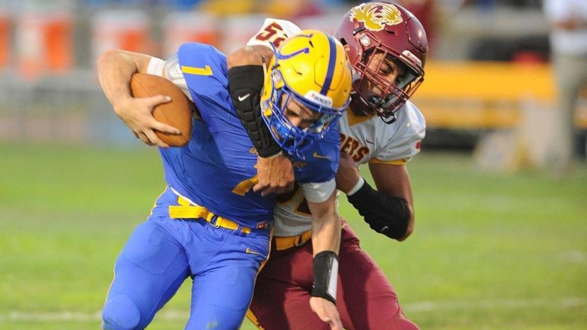 Los Banos linebacker, Junor Lemos, right, tackles Dos Palos High quarterback Isaac Adams in the first quarter Fri., Aug. 17, 2018 in Dos Palos.
