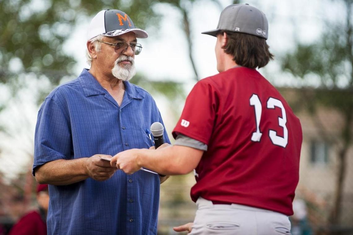 Dave Nannini, left, hands Golden Valley senior Brandon Garcia (13) a scholarship in the name of his two sons Brian and Kevin Nannini, during the 14th annual Nannini game between Merced and Golden Valley at Merced High School in Merced, Calif., on Friday, May 5, 2017. Brian and Kevin both died in a boating accident in 2004. The Cougars beat the Bears 14-2.