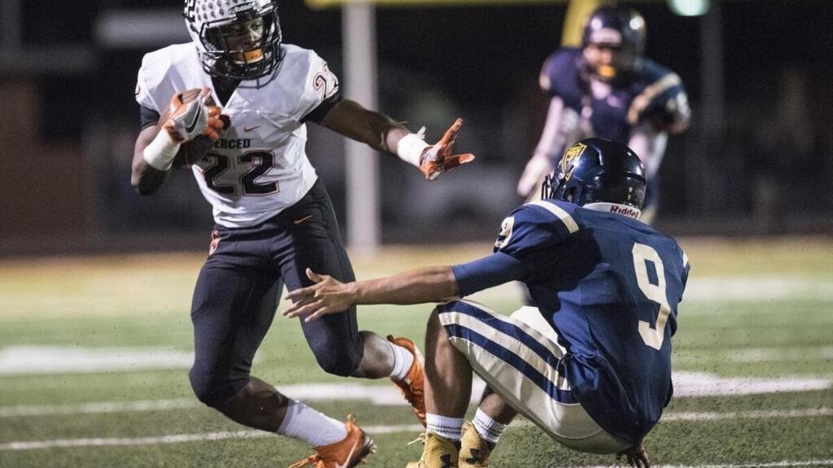 Merced senior running back Rayveon Slaton (22) slips past Turlock senior linebacker Alex Oliveira (9) during a game at Joe Debely Stadium in Turlock, Calif., Friday, Oct. 28, 2016. The Bulldogs beat the Bears 27-20.