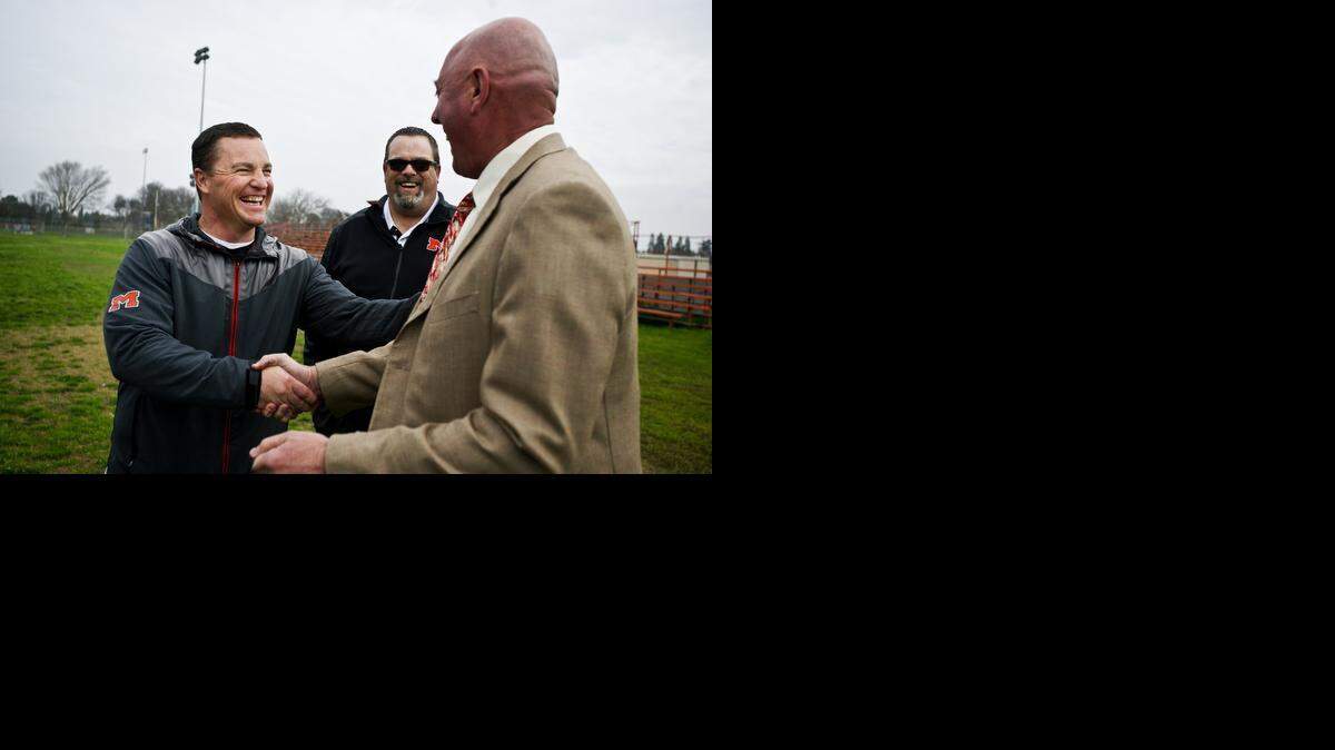 
Merced High School football head coach Rob Scheidt, left, shakes hands with Greg Hostetler of Hostetler Ranches as athletic director Paul Hogue looks on following a donation by Hostetler of 8.33 acres of land to the Merced High Quarterback Club on Thursday. The Merced High School Quarterback Club will sell the land to raise money, which will be used to build a new football stadium on campus.

