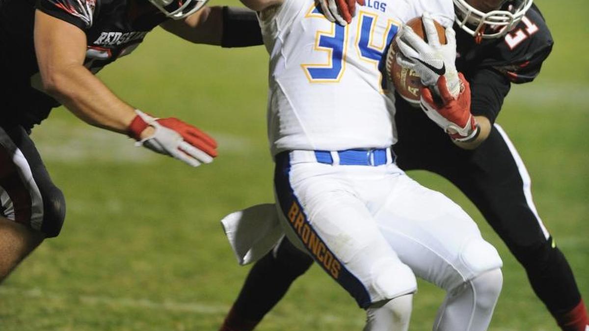 Dos Palos running back Hunter Hogue is taken down Friday by Chowchilla’s Wyatt Sparkman, left, and Alfonso Chaldez.