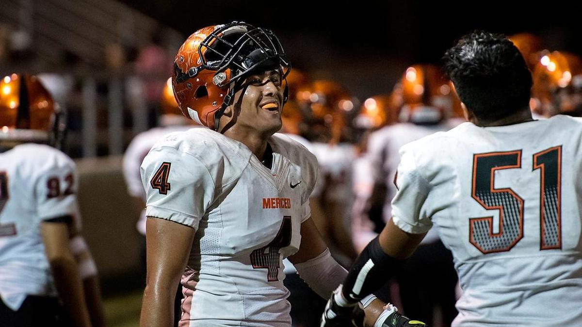 Merced's John Becerra talks with teammate during the non-conference game with Lincoln in Stockton on Friday. Merced won the game 33-20.