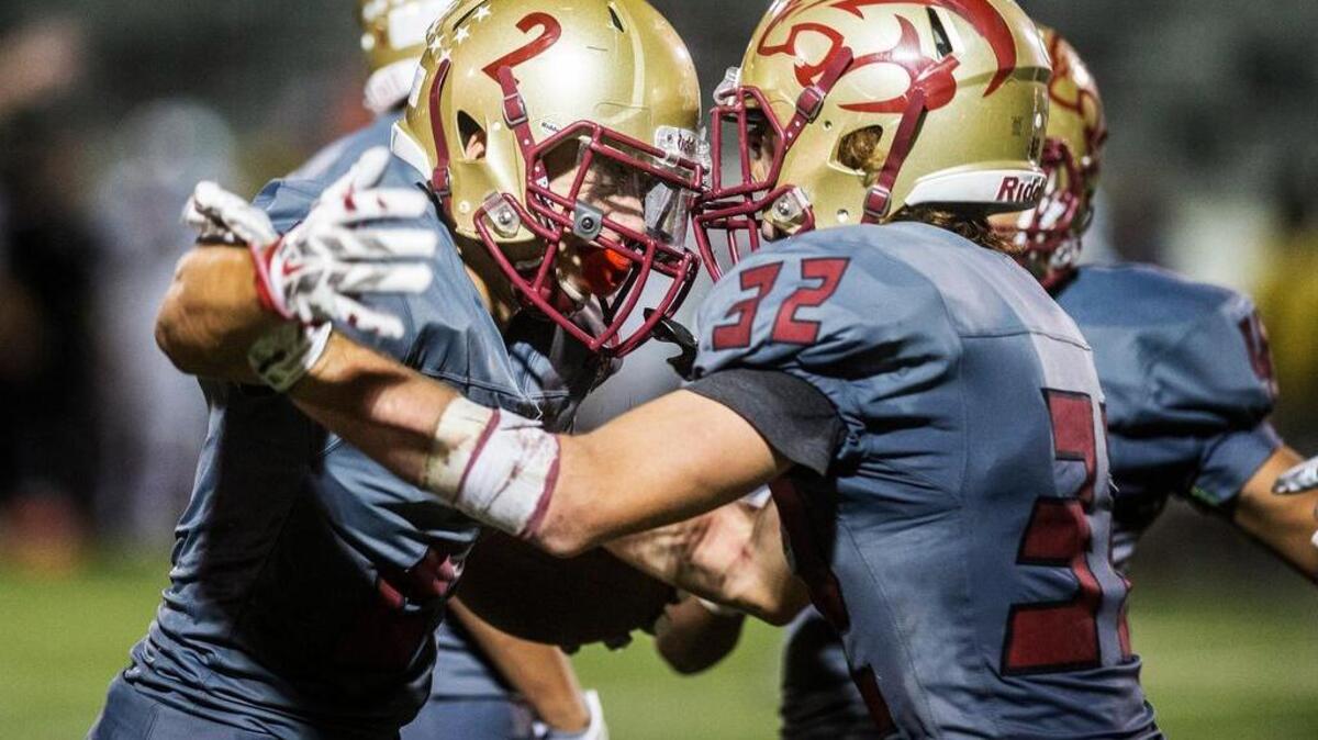 Golden Valley’s Kris Lemas, left celebrates an interception against Chavez in September with Nick Lemas.