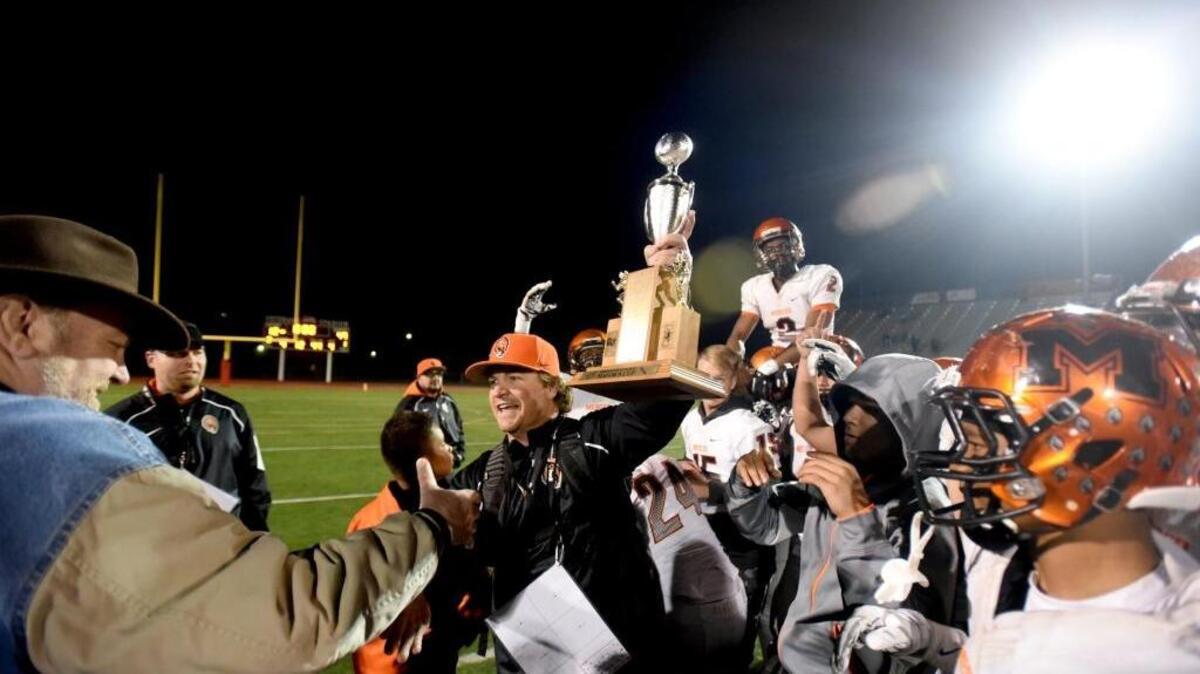 Merced's Coach Rob Scheidt reaches out to shake Mayor Stan Thurston's hand after the Mayor handed him the Mayor's Cup trophy, during the Battle for the Mayor's Cup between crosstown rivals Merced High and Golden Valley High on Friday (11-6-15) in Merced.
