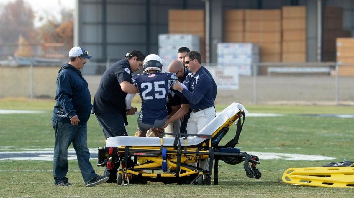 Stone Ridge Christian's Shane Casillas (25) is lifted onto a stretcher after injuring his left leg, during the CIF State Play-In Game between the Mission High Bears of San Francisco and the Stone Ridge Christian High Knights on Saturday (12-5-15) at the Valley Sports Academy in Atwater.