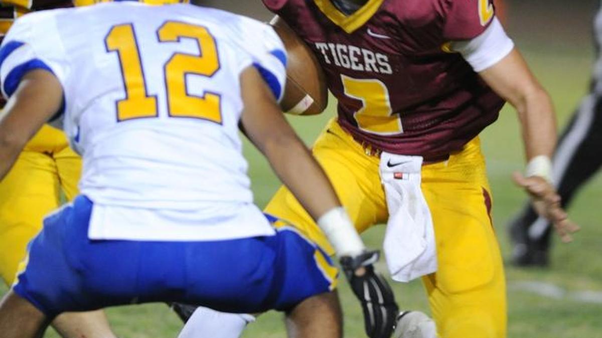 
Los Banos quarterback Adam Herrera (2) tries to juke Dos Palos’ Marc Jimenez in a 43-6 LB victory on Friday night.
