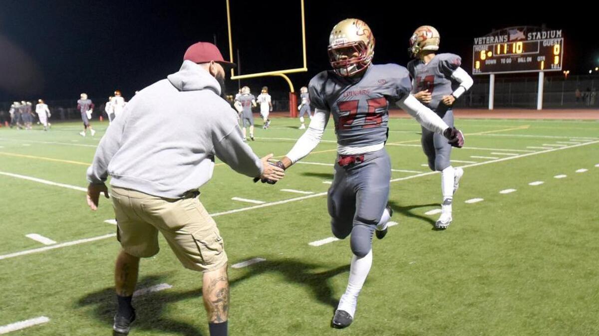 Golden Valley's Isaiah Montanez (25) is congratulated after scoring the first touchdown of the game, during the Battle for the Mayor's Cup between crosstown rivals Merced High and Golden Valley High on Friday (11-6-15) in Merced.