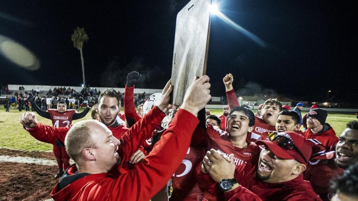 Chowchilla head coach Alex Pittz holds up the championship trophy as the Redskins celebrate a 28-16 win over Fairfax during the Southern California Regional IV-AA Bowl Championship game at Chowchilla High School in Chowchilla Calif., Saturday, Dec. 12, 2015.