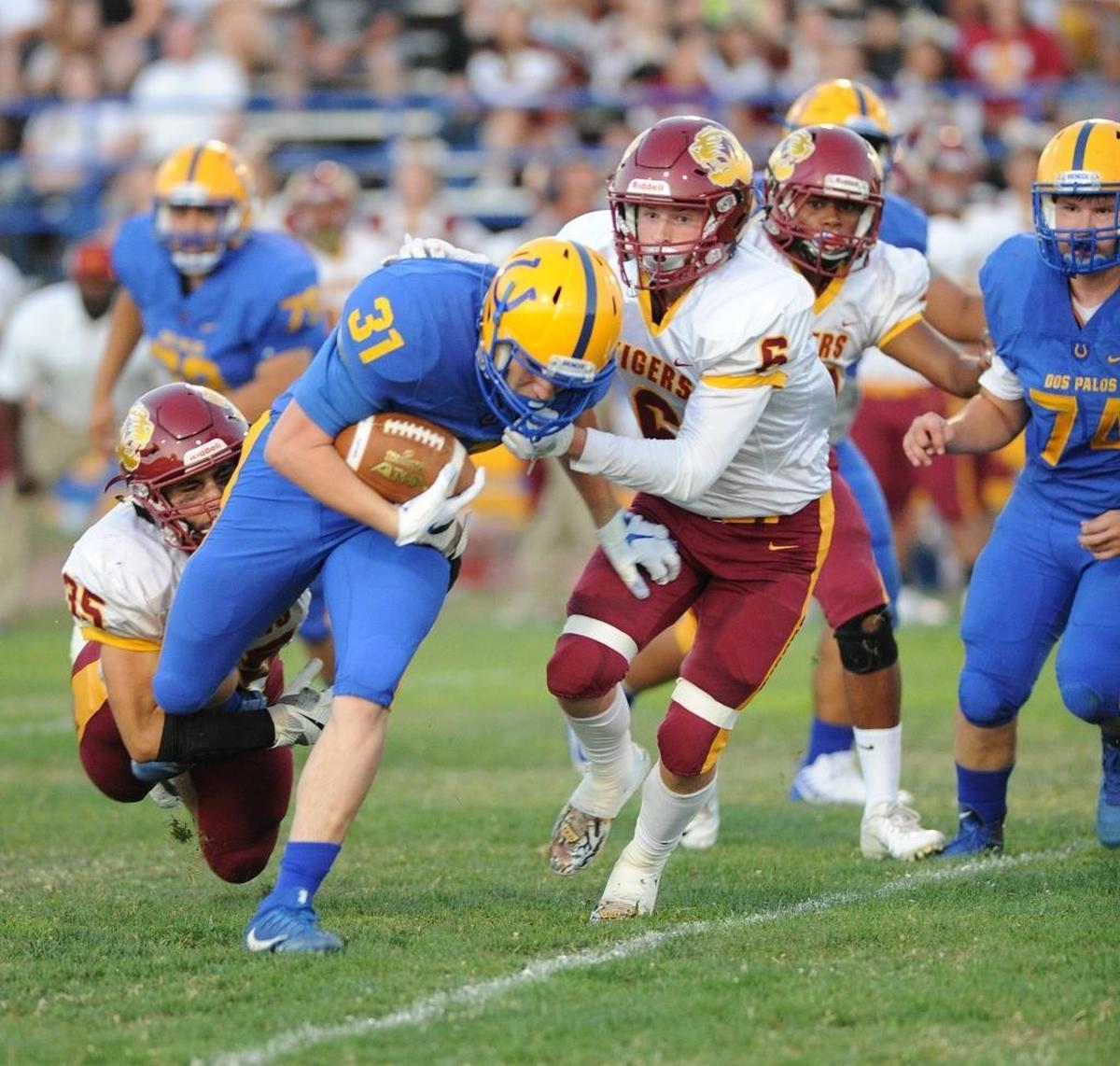 Los Banos defenders, Patrick Nunes, left, and Logan Borchard, right, take down Dos Palos runner, Ryan Ramirez in the first quarter Fri., Aug. 17, 2018 in Dos Palos.