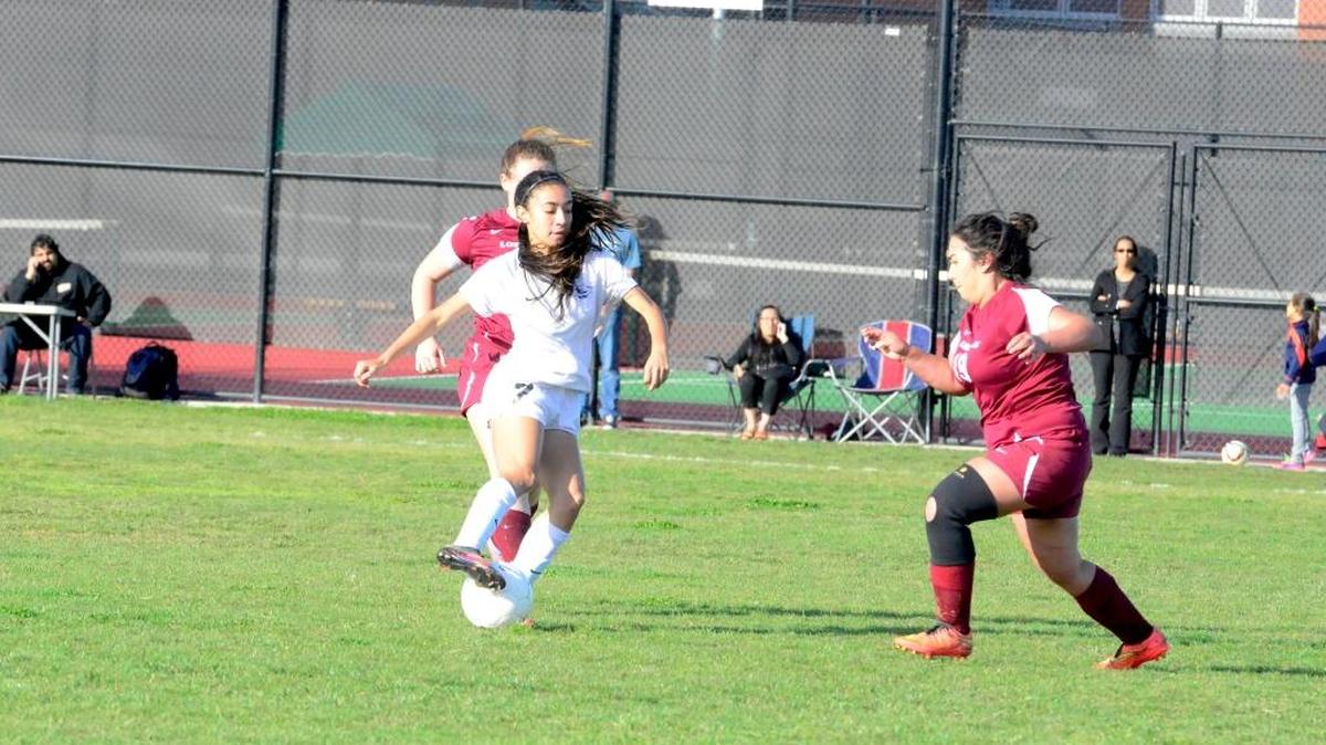 El Capitan's Bryna Vega, center, drags the ball back as she attempts to split a pair of Los Banos defenders on Monday afternoon. Vega had a hat trick in the 8-0 victory. Monday, March 14, 2016 in Merced.