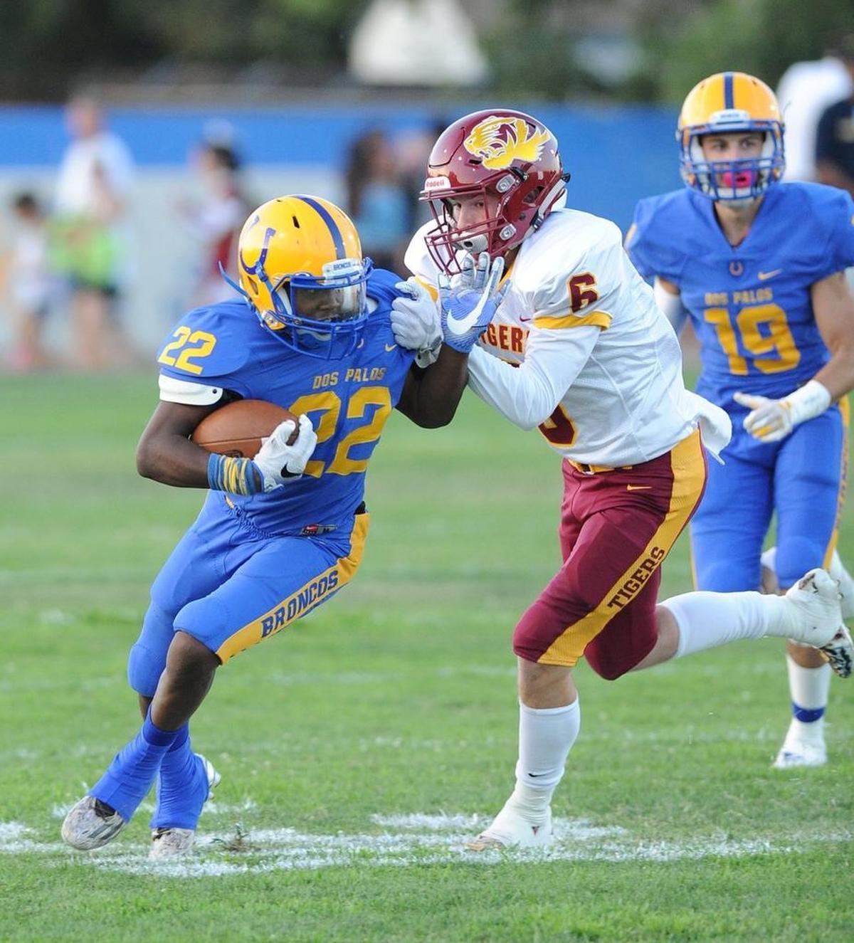 Dos Palos High runner Ronald Johnson, left, can’t get away from Los Banos’ Logan Borchard in the first quarter Friday night, Aug. 17, 2018 in Dos Palos.