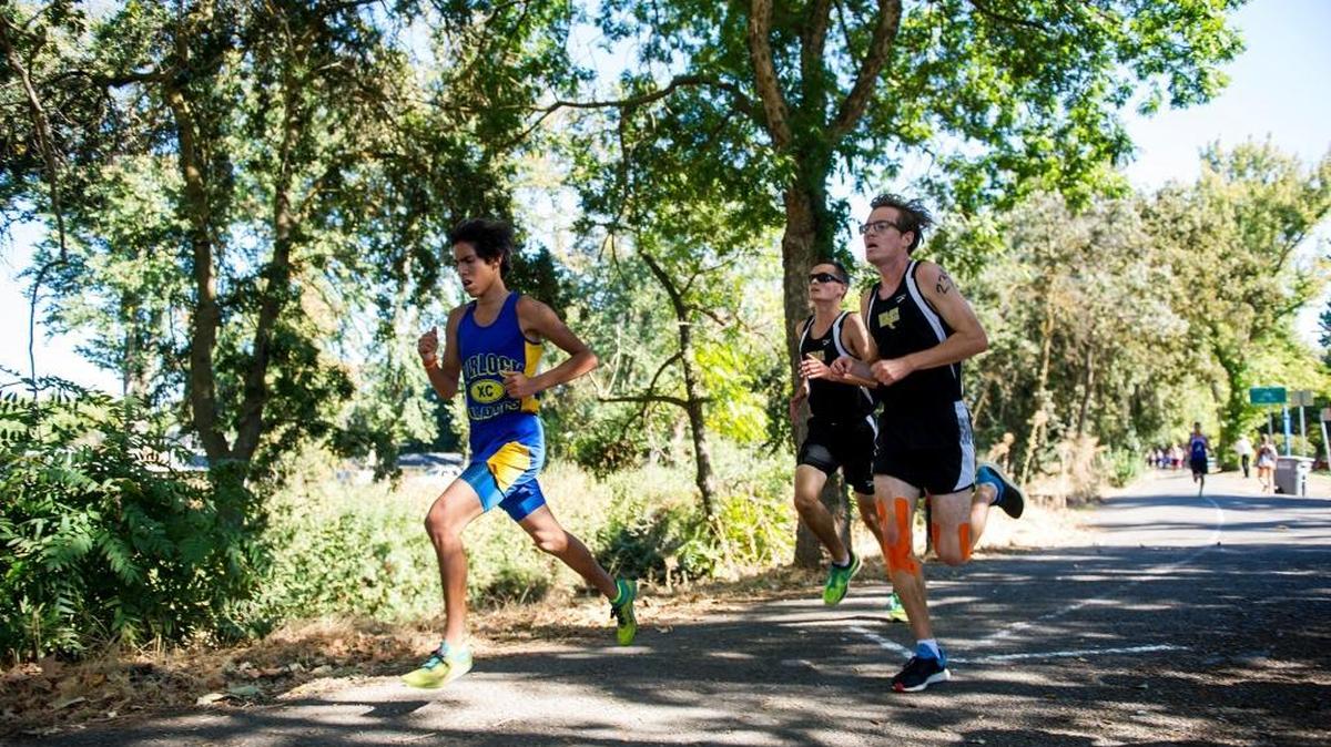 Boys cross country runners make their way along the bike path during the CCC Center Meet at Applegate Park in Merced in 2016.