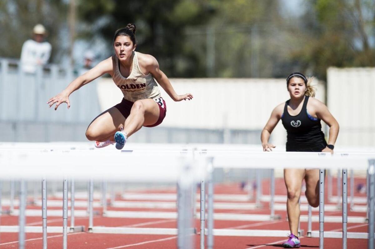 Golden Valley senior Gillian Gong, left, competes in the girls 100-meter hurdles during the CCC Center Meet at Golden Valley High School in Merced, Calif., on Wednesday, March 28, 2018.