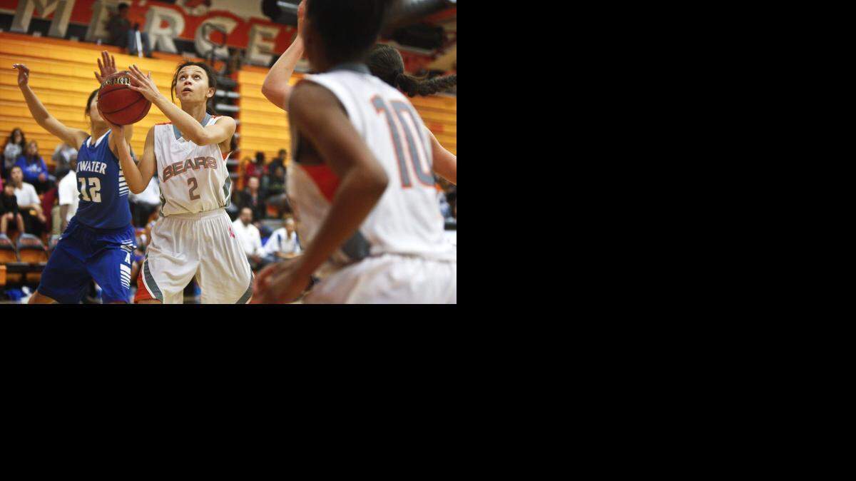 Merced senior Samra Dinkins drives to the basket against Atwater’s Jasmine Xiong<137>✔<137> at Merced High School on Thursday.