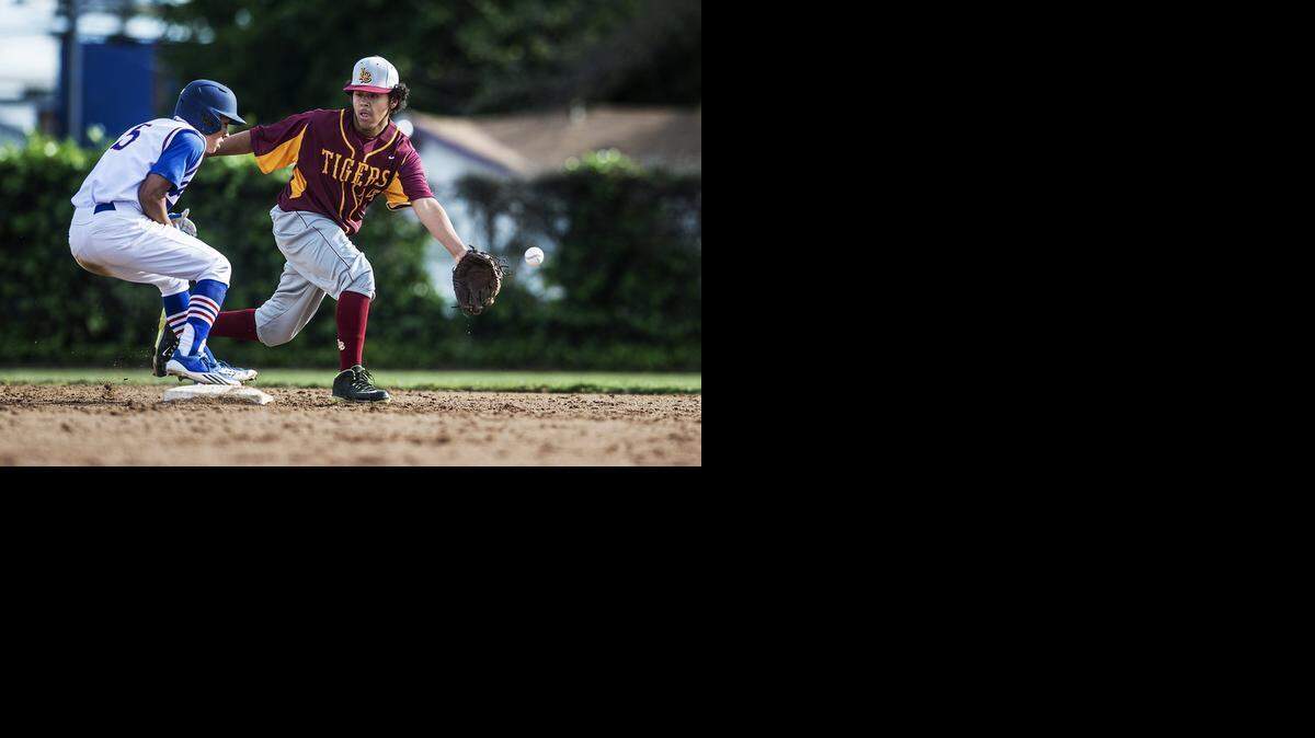 Los Banos shortstop Christian Corral, right, can’t catch this pickoff throw at second base against San Leandro on Tuesday. <137>in the Fran Oneto/Atwater-Winton Lions Easter Baseball Tournament at Fireman's Memorial Ballpark in Atwater on Tuesday. San Leandro beat the Tigers 9-0.<137>