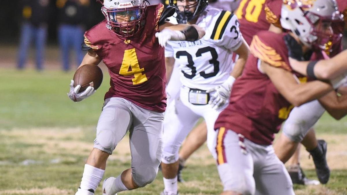 Los Banos running back Antonio Lopez, left, looks for some blocking in the first quarter Fri., Nov. 10, 2017 against Rio Linda High at Loftin Stadium in Los Banos.