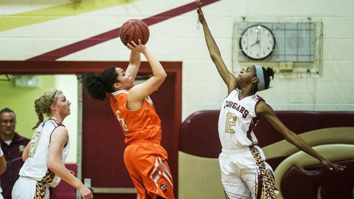 Golden Valley junior Kayla Commons (12) attempts to block a jump shot by Merced senior Symone Gilliam (5) during a game at Golden Valley High School in Merced, Calif., Thursday, Jan. 21, 2016. The Cougars beat the Bears 46-32.