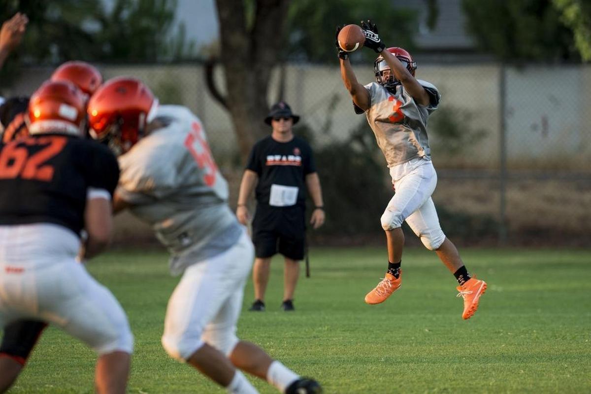 Merced’s Desmond Thompson jumps to catch a pass during football practice at Merced High School in Merced, Calif., on Wednesday, Aug. 1, 2018.